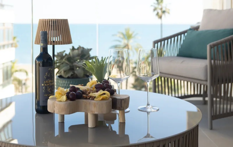 Wine and a sharing platter on the terrace table with the sea behind