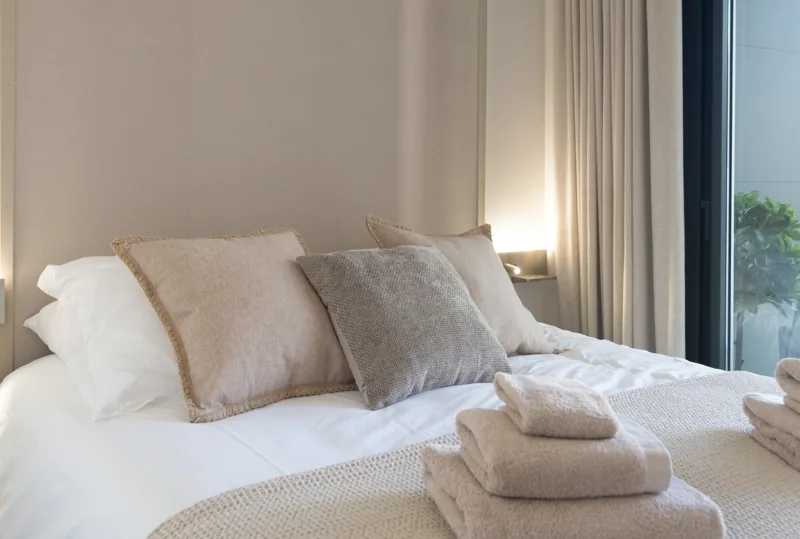 Soft bedding and folded towels in the principal bedroom