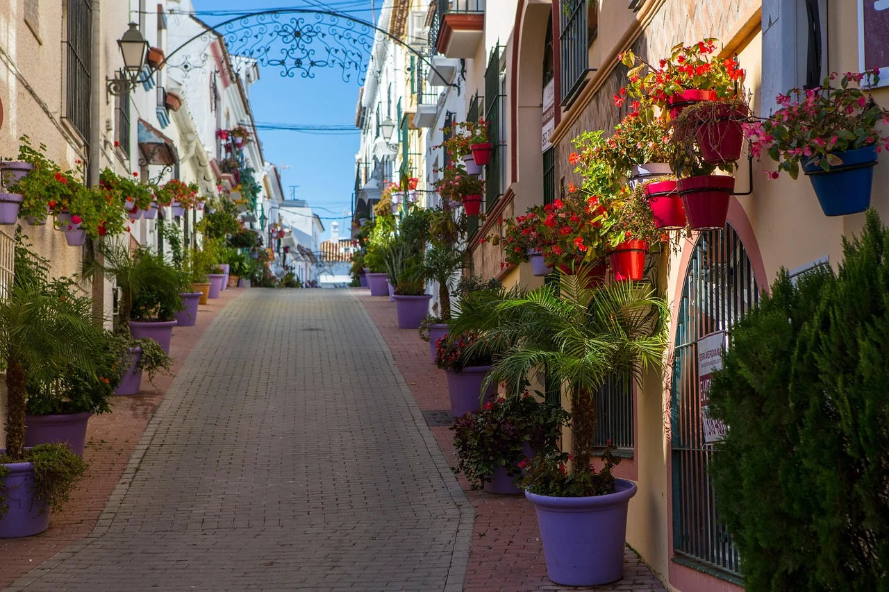 An inviting lane in Estepona old town, lined with white façades, bright flowers and colourful pots